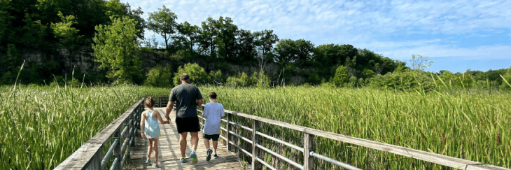 Dad and kids walkiing along boardwalk at Kerncliff Park