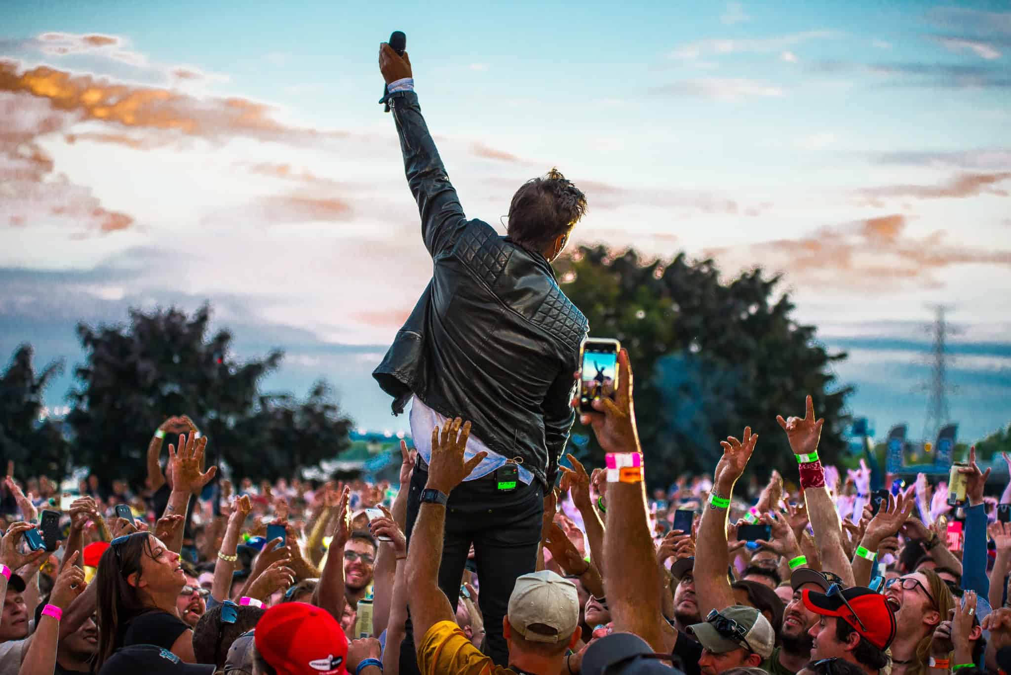 Performer standing up above the crowd at Sound of Music festival with fans taking pictures