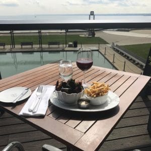 Spencers patio overlooking lake with meal and wine on table