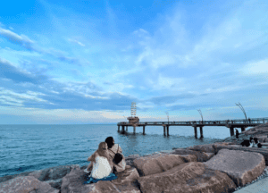 Pier with 2 people sitting on rocks